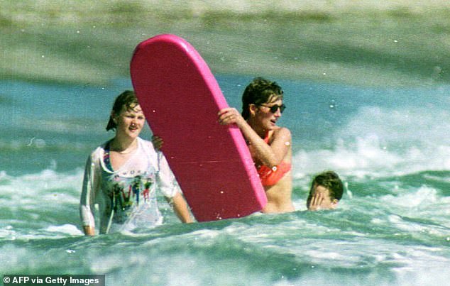 The princess attempts to catch a wave with her bright pink board in Nevis