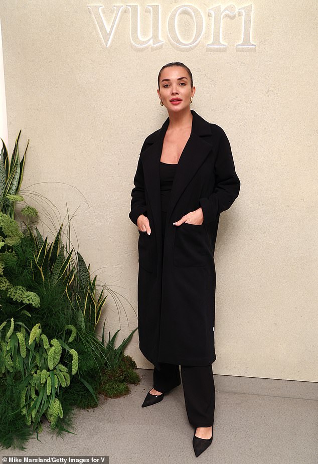 Meanwhile, Amy cut a stylish figure in a black tailored coat and a black jumpsuit