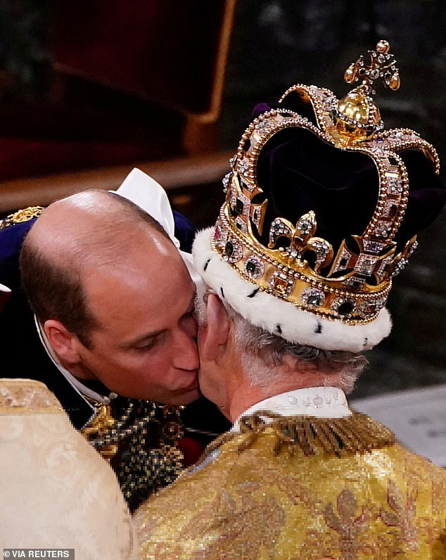 Prince William kisses his father King Charles on the cheek during the monarch's coronation ceremony in 2023