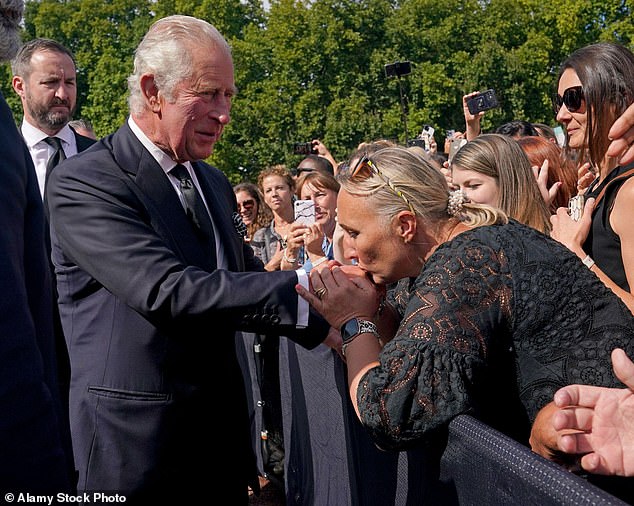 After his mother died in September 2022, the new King put on a brave face for the country as he shook the hands of well-wishers at Buckingham Palace. In an outpouring of affection, one woman leaned over to kiss his hand (pictured)