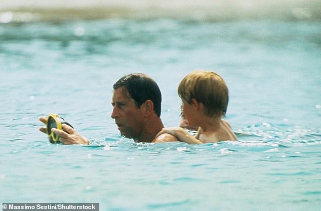 Prince Charles gives Harry a piggy back while swimming