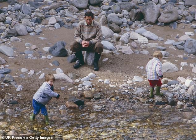 Prince Charles, Prince William, and Prince Harry play on the bank of the River Dee, near Balmoral Estate, Scotland, on April 10, 1987