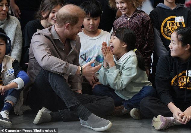 Sharing a giggle! Marjorie Yuan, centre right, reacts as she talks with Prince Harry