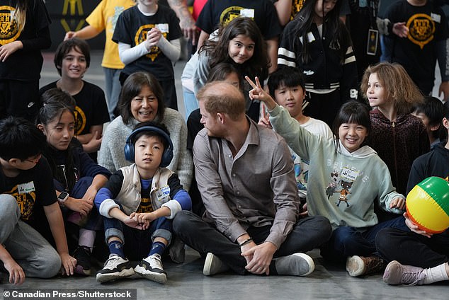 Marjorie Yuan, right, holds up bunny ears behind Prince Harry, the Duke of Sussex, in a light-hearted moment during the official Invictus Games event in Vancouver