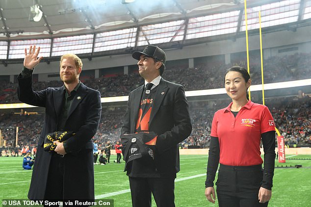 Prince Harry waves to fans ahead of the game between Toronto Argonauts and Winnipeg blue Bombers at BC Place on Sunday