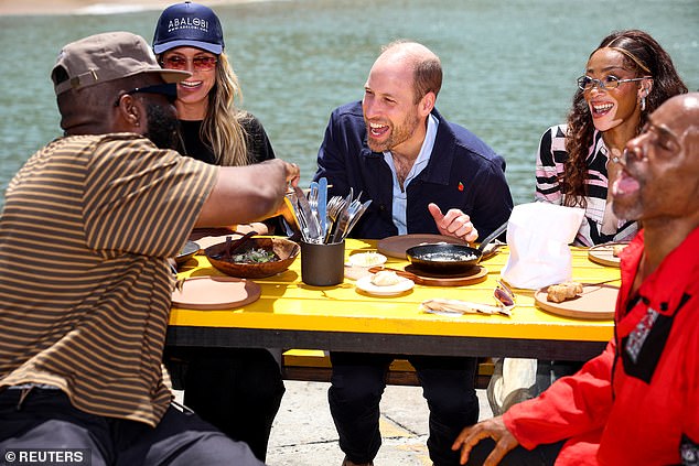 William appeared to share a joke as he and his pals tucked into a traditional fish brai lunch on the harbour