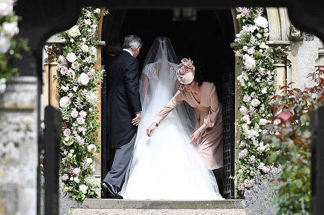 Kate adjusting her sister's dress as she enters the church on her wedding day