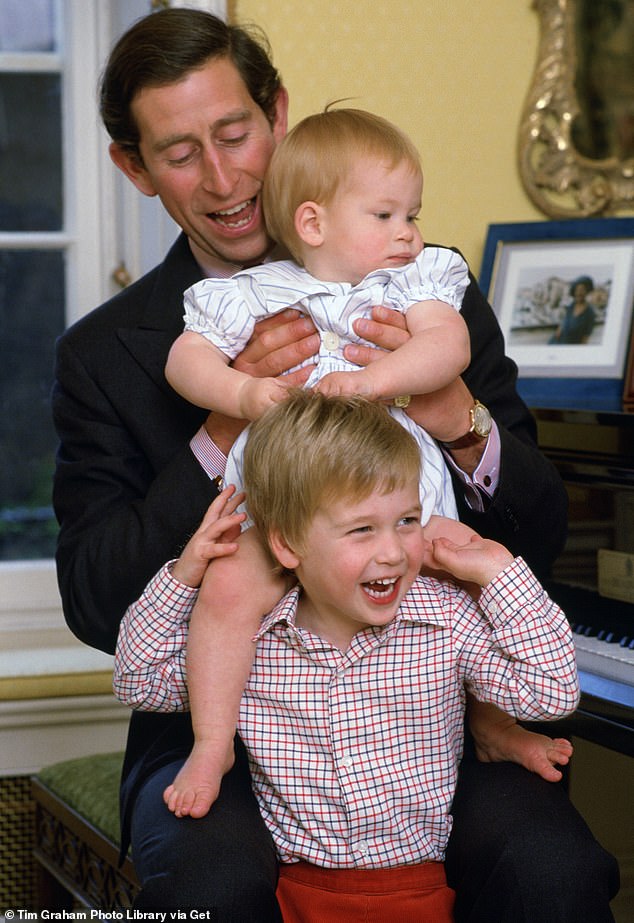 Prince Charles laughs with his sons as he lifts Prince Harry on to Prince William's shoulder in Kensington Palace for this sweet family photo in 1985