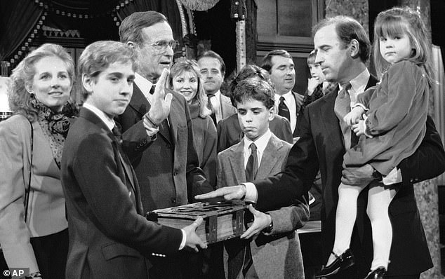 Ashley Biden in her father's arms (right) as he took an oath in Congress in 1985. Her brother Beau (left) holds up the Bible with his brother Hunter (centre) while Ashley's mother Jill (far left) looks on