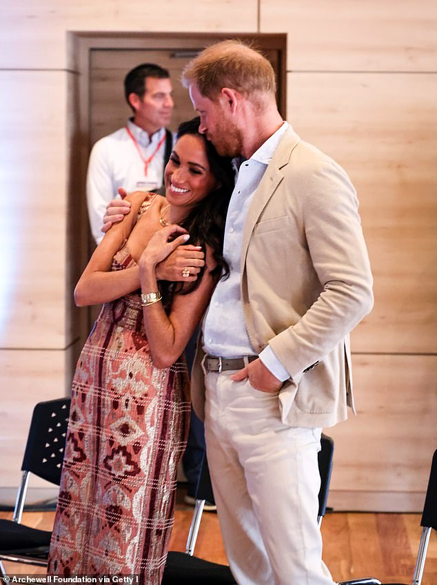 Prince Harry plants a kiss on Meghan's forehead in a photo taken during their four-day visit to Colombia in August