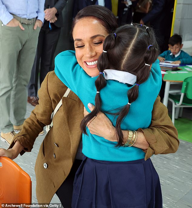 The first image on the Sussex's Christmas card showed 'hugger' Meghan embracing a pupil at Colegio La Giralda