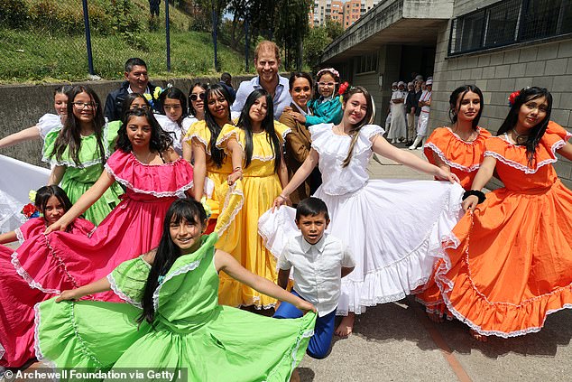 Meghan and Harry were all smiles as they took a photo with students wearing traditional Colombian clothing