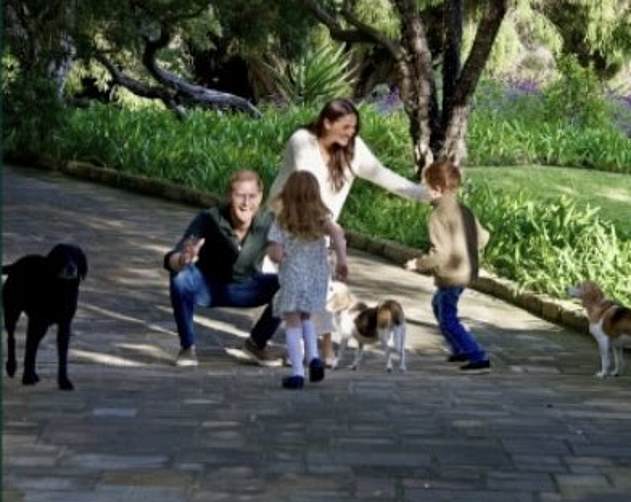 The close-up of the family photo of the Sussexes shows the doting parents greeting their children - Prince Archie and Princess Lilibet - with open arms