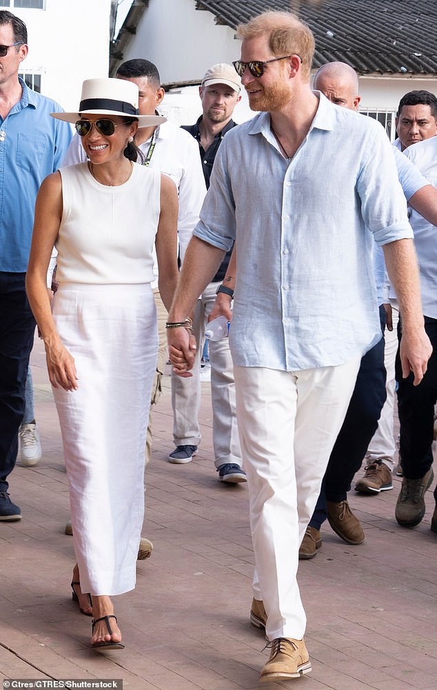 Pictured: The Duke and Duchess of Sussex holding hands during a visit to San Basilio de Palenque in August