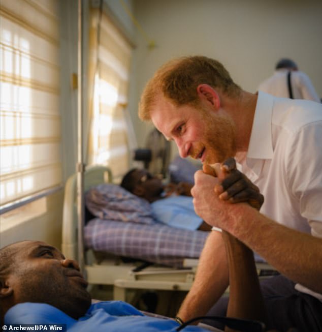 The final image on the card showed the royal holding hands with a patient at a Nigerian military hospital