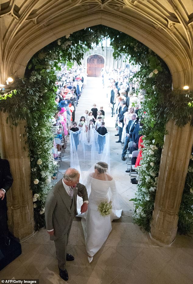 The pair seemed to share a few secret words before they linked arms and walked towards the altar at Meghan and Harry's wedding in May 2018