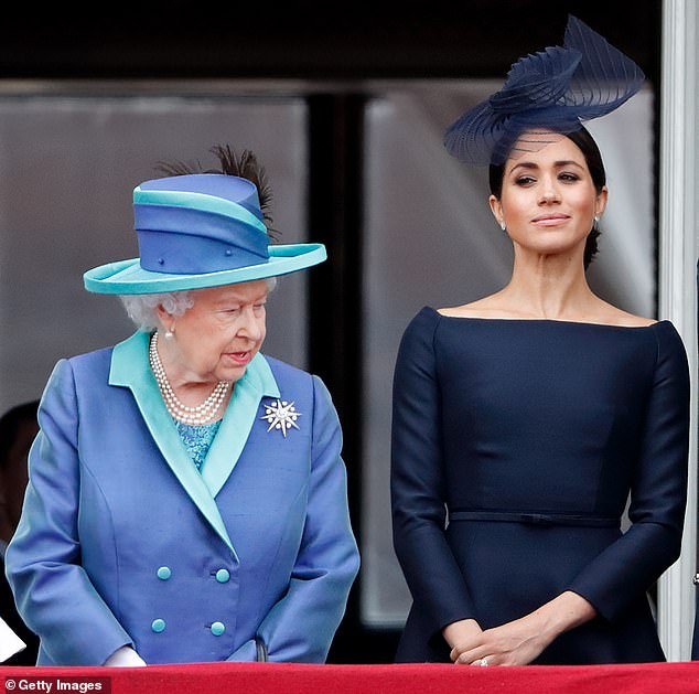 Queen Elizabeth II and Meghan watch a flypast to mark the centenary of the Royal Air Force from the balcony of Buckingham Palace on July 10, 2018