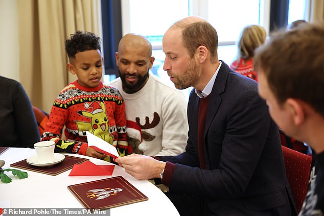 William is seen chatting to the families at the barracks today