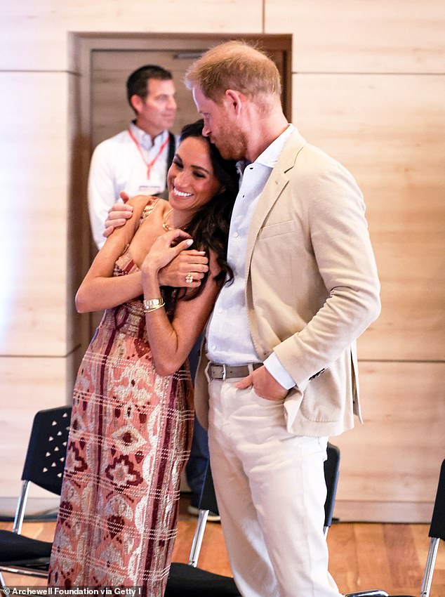 Prince Harry embraces his wife Meghan Markle during their tour of Colombia in August