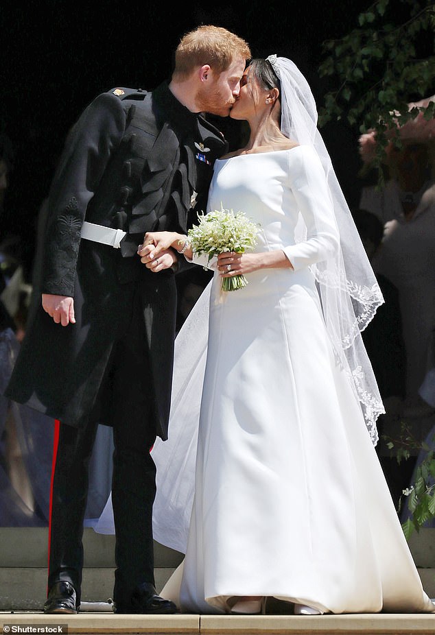 The happy couple share a kiss on their wedding day outside of St George's Chapel on May 19, 2018. Meghan wore a long silk dress made by French fashion house Givenchy and Clare Waight Keller