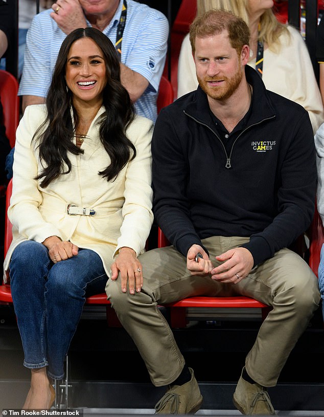 Meghan places her hand on Harry's knee and smiles as the couple attend the Invictus Games in the Netherlands, 2022