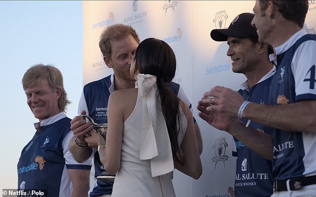 The documentary shows the couple enjoying a celebratory kiss - with Meghan presenting Harry with the trophy as they packed on the PDA for the Netflix crew