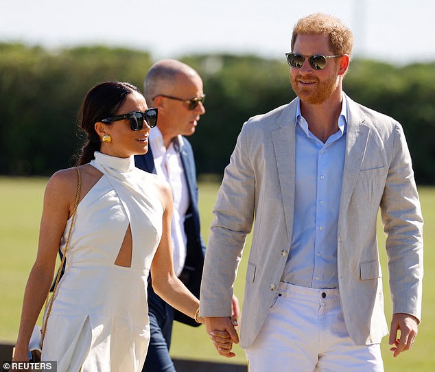 Meghan embraced the beaming sunshine in an elegant white dress, which featured a pleated skirt design, halterneck top, and a cut-out at the waist