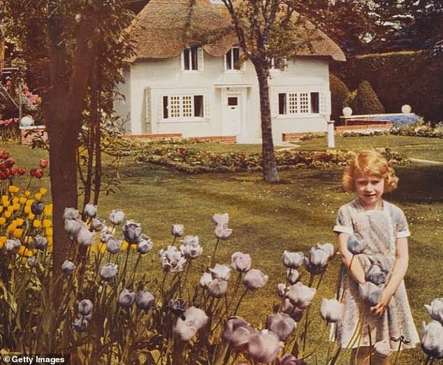 Princess Elizabeth in the grounds of the Royal Lodge with the Welsh House, Y Bwthyn Bach, presented to her by the people of Wales in the background in June 1936