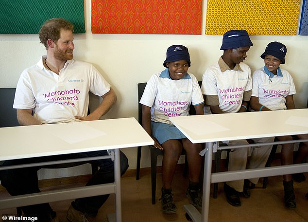 The Duke of Sussex sitting next to children at Mamohato Children's Centre in Lesotho in 2015