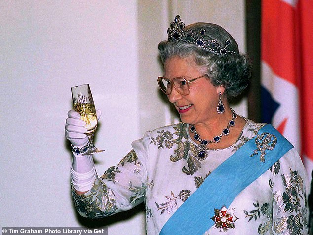 The late Queen toasting with a glass of champagne during a visit to Poland in 1996