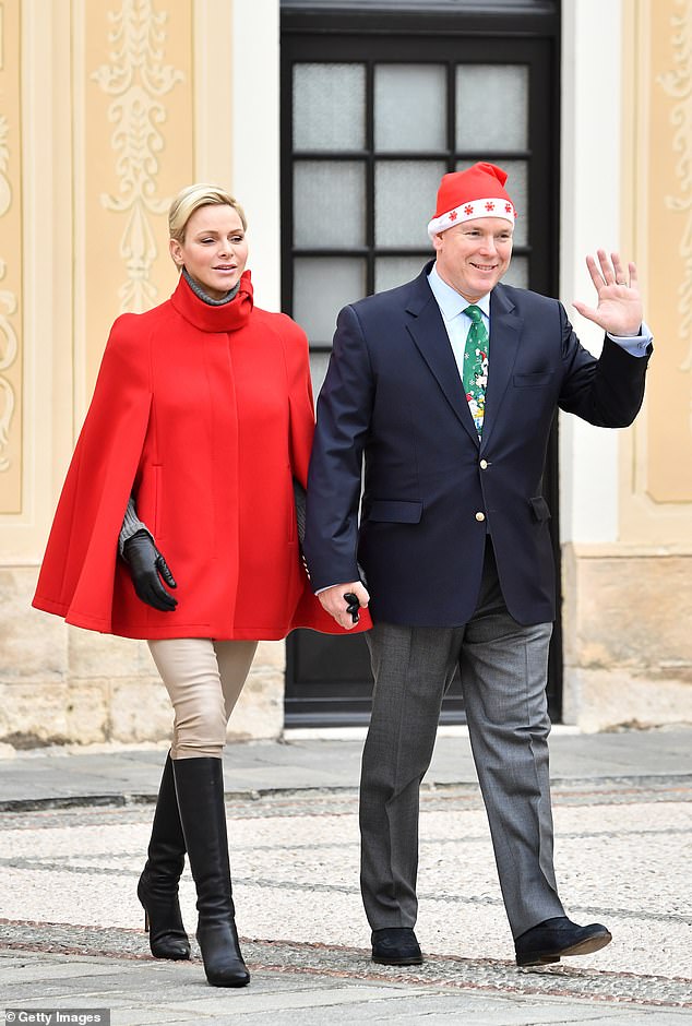 Princess Charlene and Prince Albert of Monaco, dressed in a festive hat and tie, in 2017