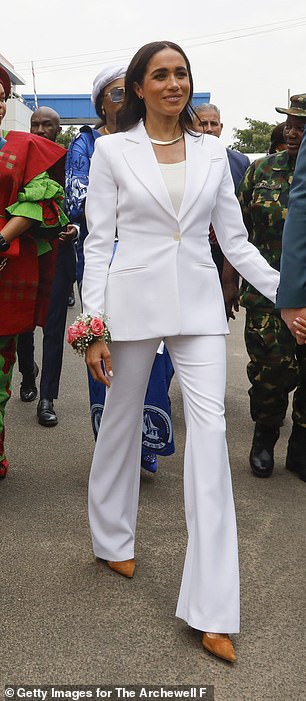 Meghan also wore a single breasted white trouser suit from Altuzarra when she visited Nigeria