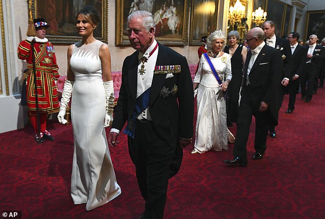 Pictured: First Lady Melania Trump walks alongside Prince Charles as they enter the ballroom for the State Banquet to welcome the US President