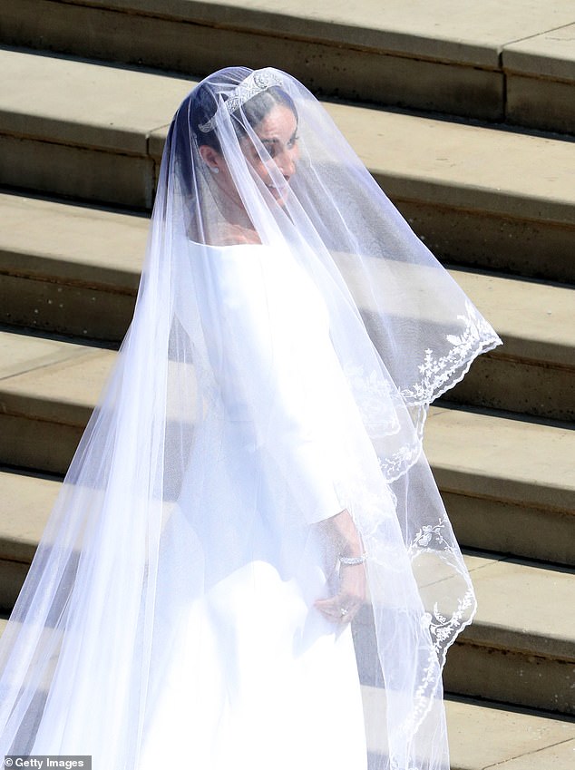 The duchess arrives for her wedding in her 16ft-long veil which was trimmed with lace depicting flora from each of the 53 Commonwealth countries