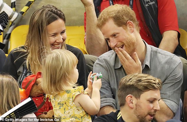 Harry smiling at toddler Emily Henson who had been sneakily eating his popcorn during a volleyball match