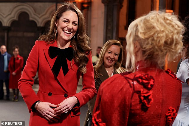 The Princess of Wales, pictured wearing an Alexander McQueen coat during the 'Together At Christmas' carol service - and chatting to singer Paloma Faith, right