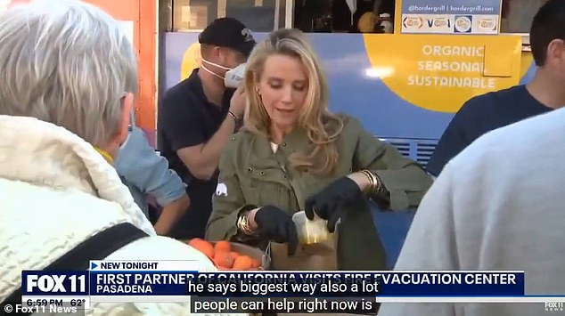 The royal couple, who live near Santa Barbara, around 90 miles away from LA, were seen comforting victims as they handed out food parcels with Jennifer Newsom (pictured centre)