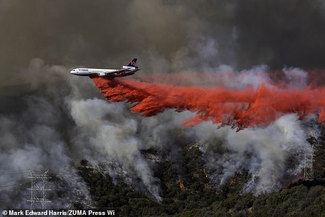 A plane drops Phos-Chek flame retardant in Mandeville Canyon during the Palisades Fire, LA - January 11, 2025