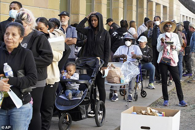 People affected by wildfires wait in line for food and aid at the Pasadena Convention Center