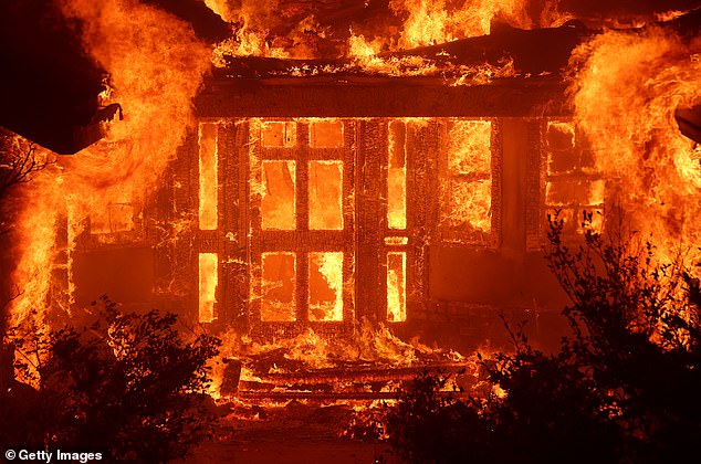 Flames from the Eaton fire in Altadena engulf a home as the huge blaze moves through the area