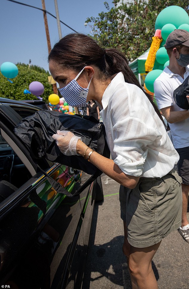 Meghan is pictured volunteering with Baby2Baby at Dr Owen Lloyd Knox Elementary School in Los Angeles, issuing free supplies to people who needed them during the pandemic (seen in August 20202)