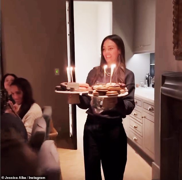 Meghan, dressed in a sleeveless white top, was filmed smiling and clapping as they sang Happy Birthday