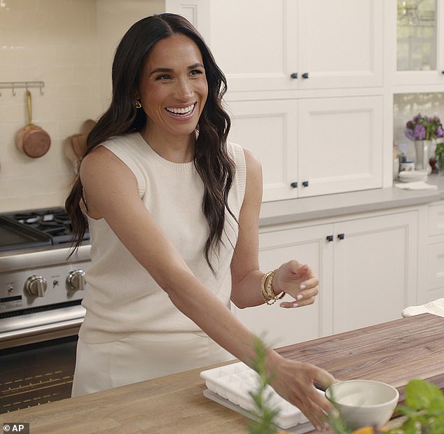 Meghan Markle is reportedly postponing the release of new episodes of her Archetypes podcast. Pictured in a scene for her Netflix show With Love, Meghan