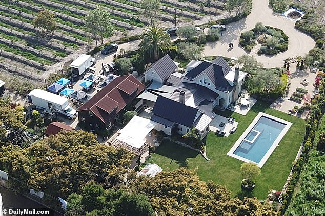 DailyMail.com can reveal Meghan is not using her own Montecito mansion, but instead using the kitchen of philanthropists Tom and Sherrie Cipolla (production trucks and tents are seen at the property)