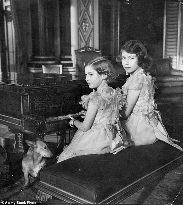 Margaret and Elizabeth, in matching dresses, playing a piano in Buckingham Palace