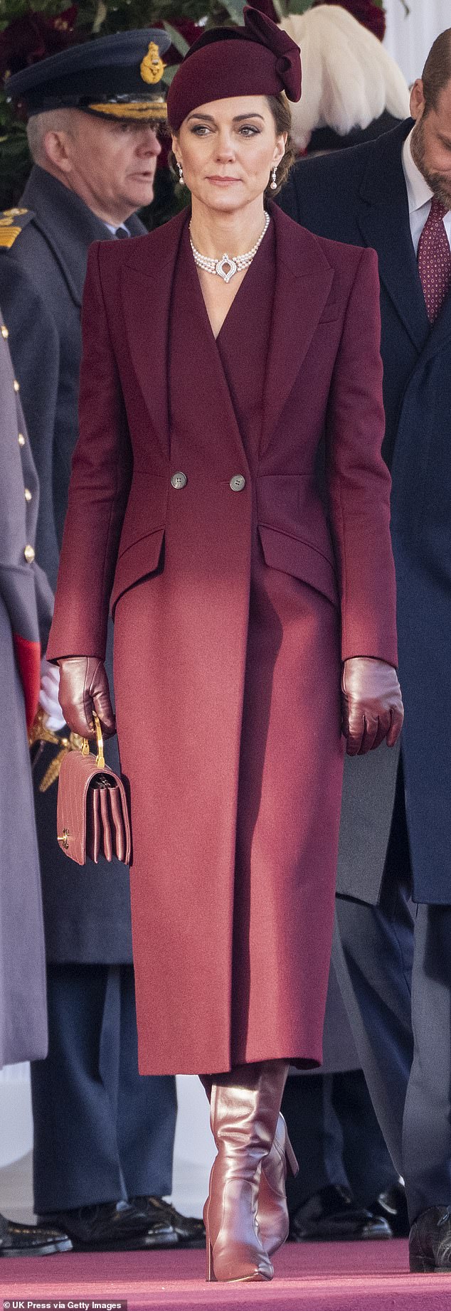 Princess of Wales is snapped wearing a burgundy coat by Alexander McQueen and a matching hat by Sahar Millinery in December 2024