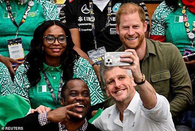 Harry poses for pictures as he attends a sitting volleyball match between Nigeria and Lithuania during the Invictus Games in Vancouver