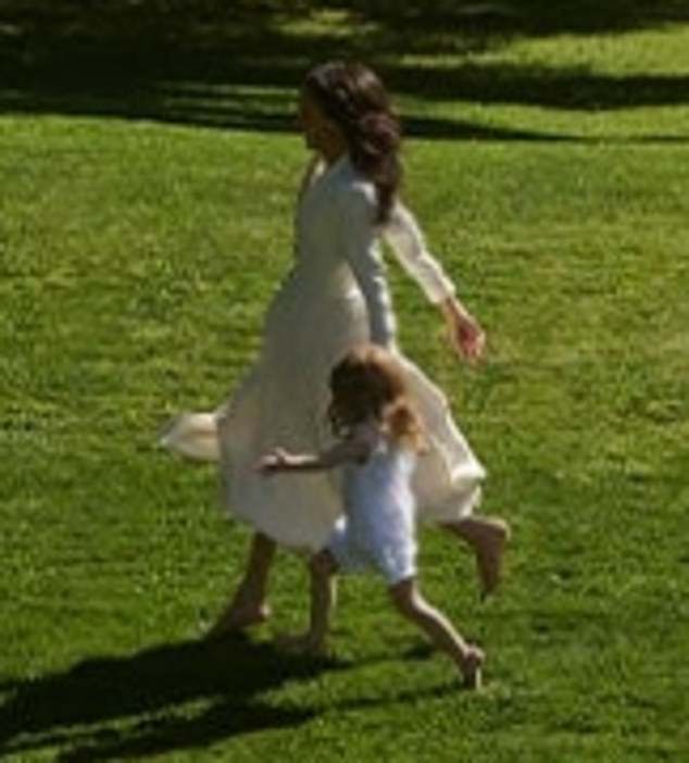 Lilibet and her mother are both barefoot  as they walk across the lawn in a rare glimpse of the three-year-old