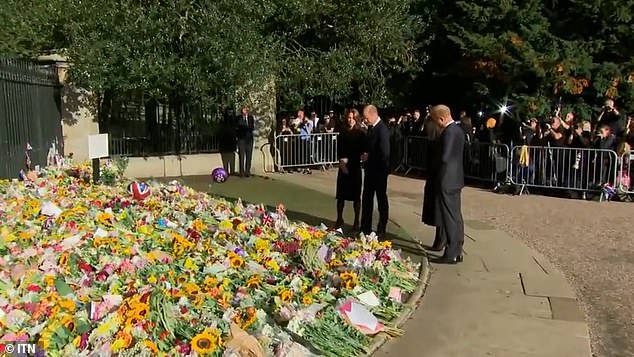 The quartet inspecting the mound of flowers that had been left outside the gates of Windsor Castle