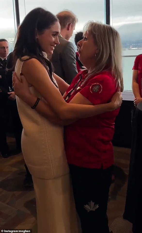 Meghan Markle hugs a woman as she and Prince Harry meet with competitors ahead of the games